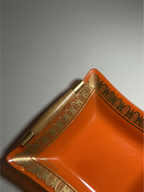 Detail of dark wood handle and brass-tone fitting on Georges Briard orange glass serving tray.