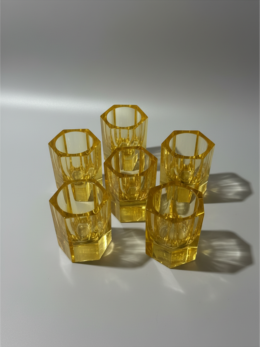 Matching amber crystal cordial glasses with substantial geometric faceted bases.