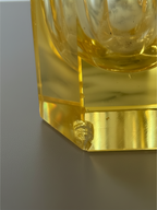 Close-up detail of an amber crystal cordial and its heavy geometric base.