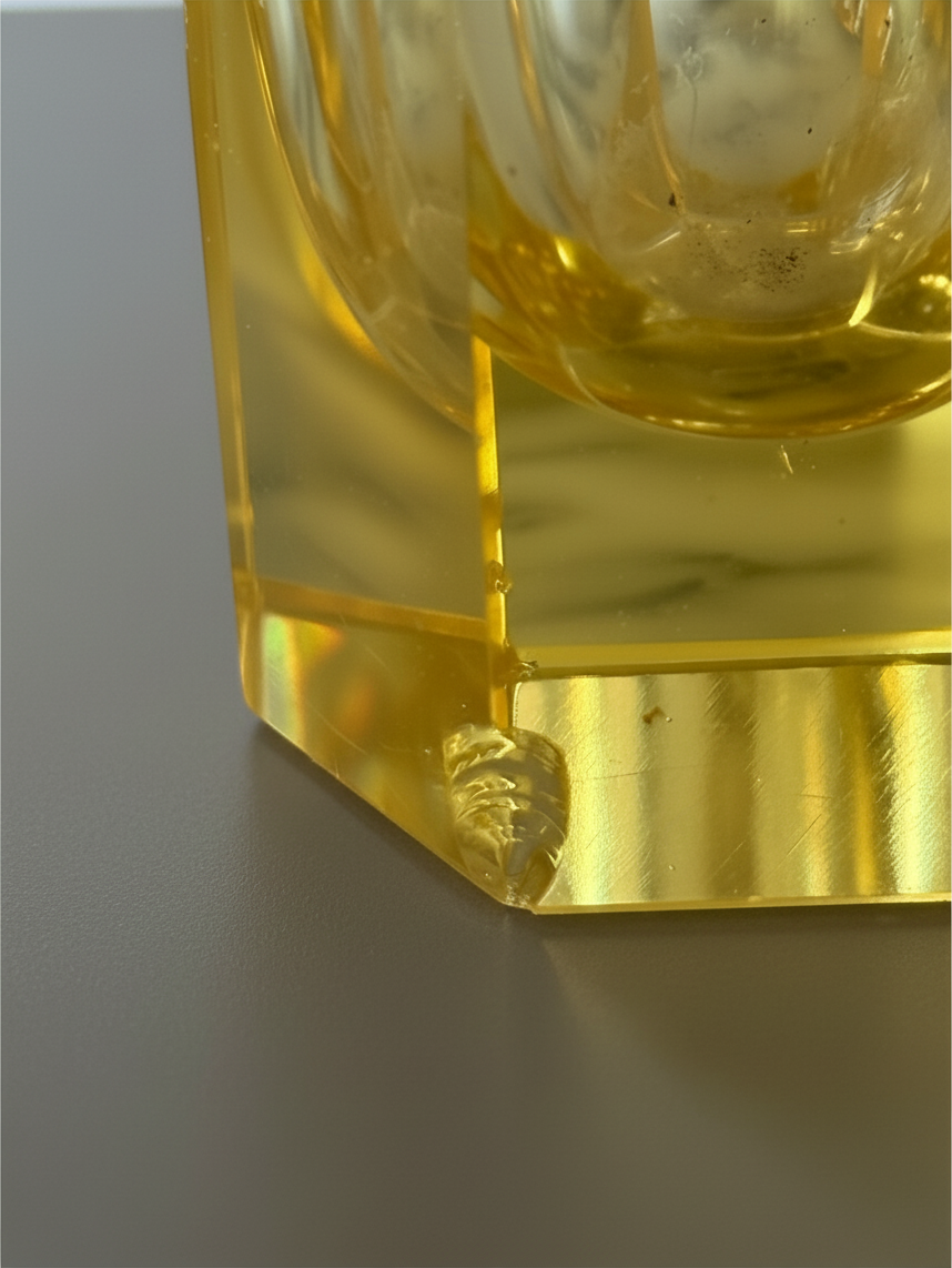 Close-up detail of an amber crystal cordial and its heavy geometric base.