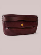Front view of 1980s Cartier clutch in burgundy pebbled leather with a gold double-C clasp.