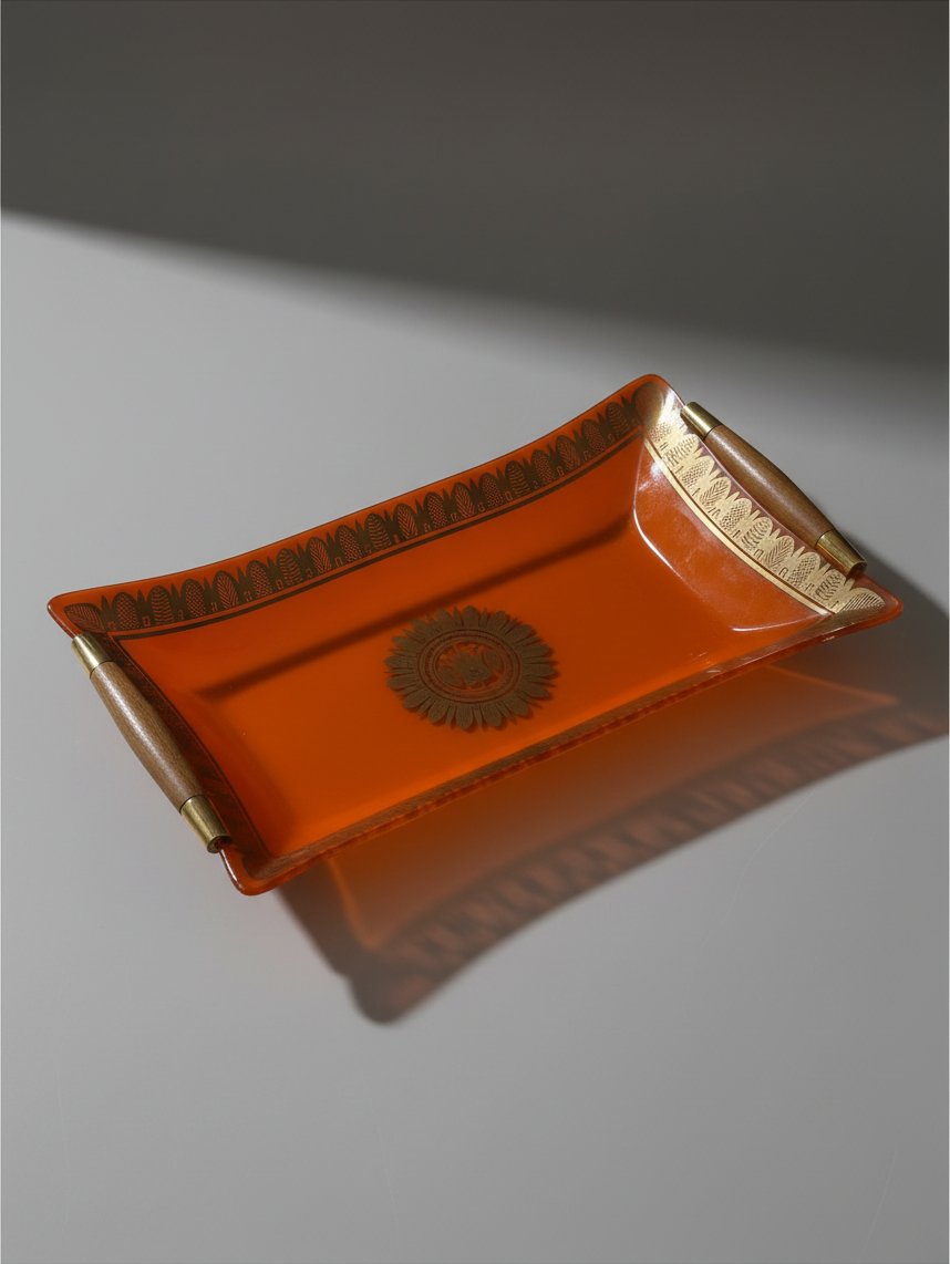 Signed Georges Briard orange glass serving tray with gilt border and dark wood handles.