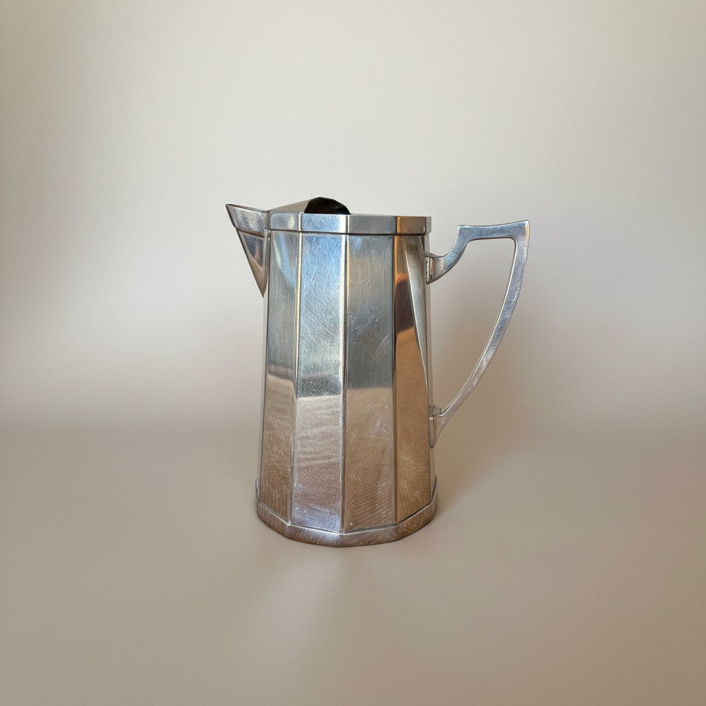 Atlas & Arden Art Deco silver plate cocktail pitcher with hinged ice guard, 1930s. Faceted design with angular handle.