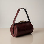 Atlas & Arden 1940s burgundy python snakeskin handbag with brass kiss-lock frame and shoulder strap.
