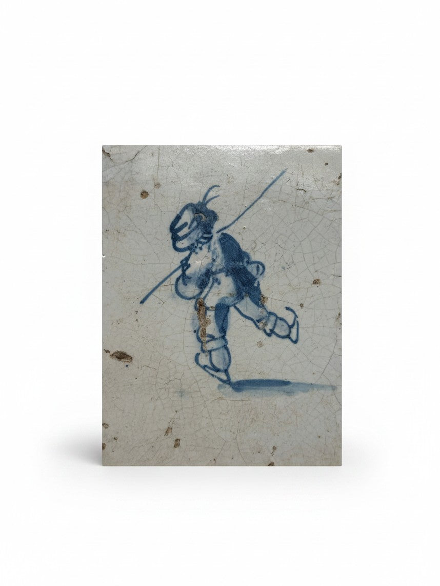 Atlas & Arden 17th-century Dutch Delft tile featuring a hand-painted blue and white pikeman with aged crazed glaze.