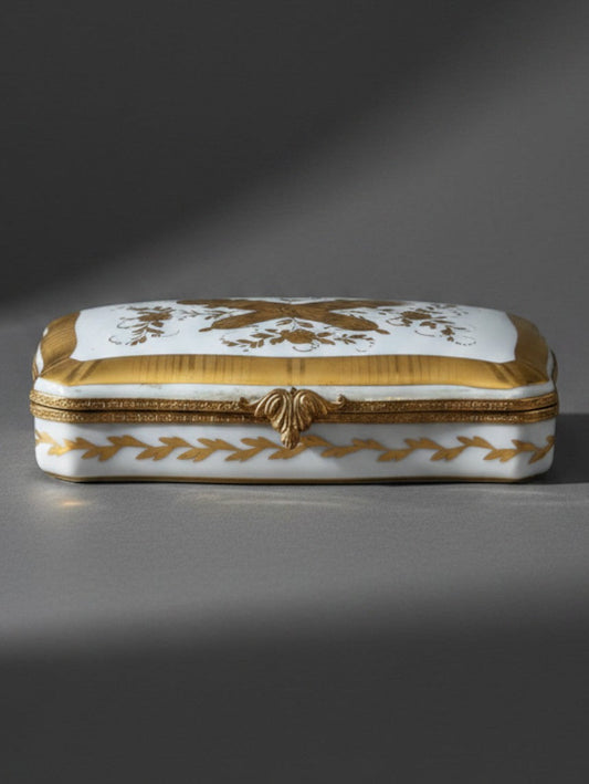 Atlas & Arden vintage Limoges porcelain box with gold gilt love trophy motifs and acanthus leaf metal clasp.