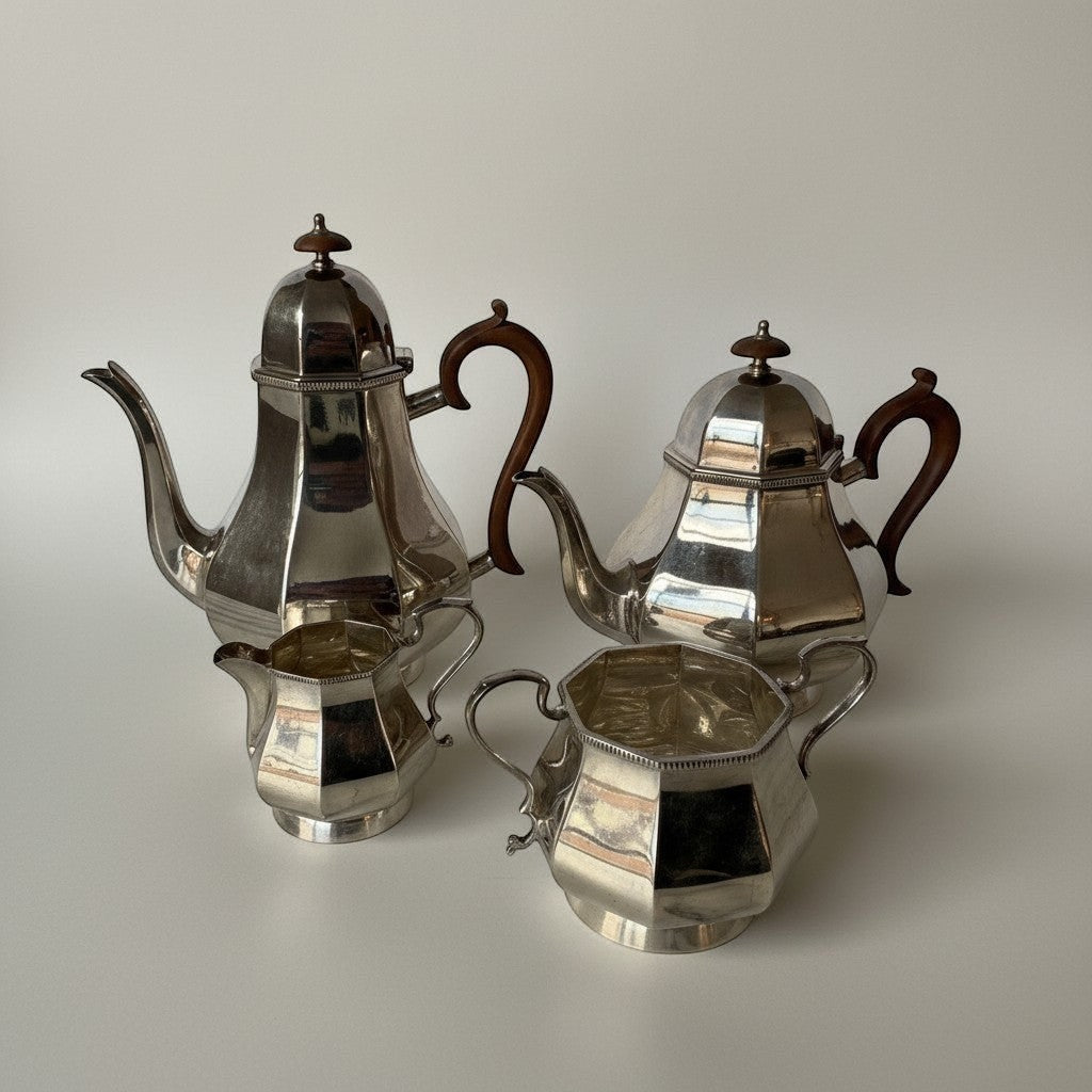 Atlas & Arden four-piece silver plate tea set with faceted bodies and warm brown Bakelite handles, mid-20th century.