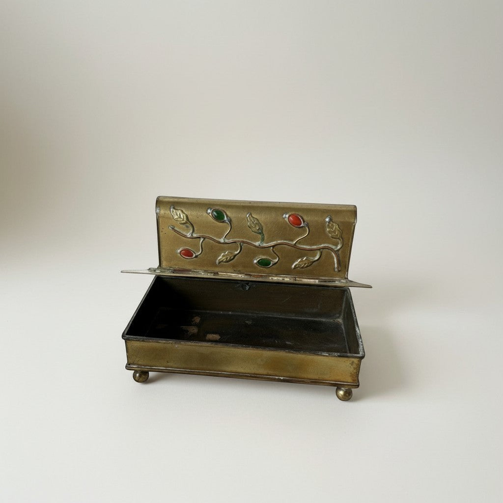 Atlas & Arden vintage brass box with ornate vine design, red and green stones, and ball feet. Hinged lid opens to reveal storage space.