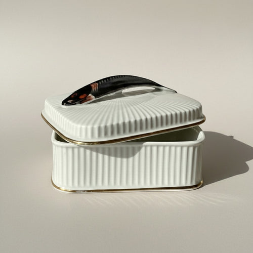 Atlas & Arden mid-century white ribbed porcelain sardine box with gold trim and a fish-shaped handle.