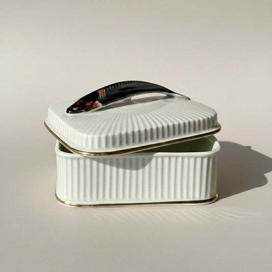 Atlas & Arden mid-century white ribbed porcelain sardine box with gold trim and a fish-shaped handle.