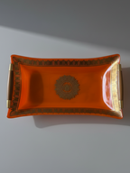Georges Briard orange glass serving tray with gilt decoration, wood handles and brass-tone fittings.