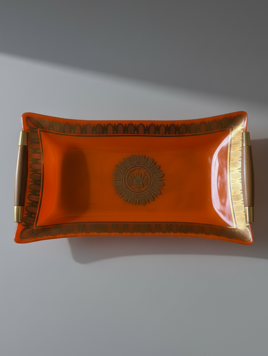 Georges Briard orange glass serving tray with gilt decoration, wood handles and brass-tone fittings.